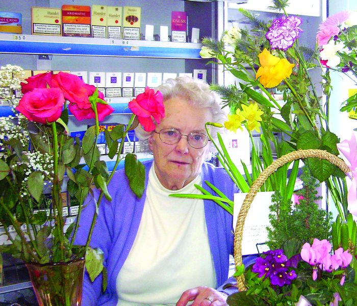 108_64 Birthday girl- picture shows Dorothy behind her counter as usual but surrounded by 80th birthday flowers.