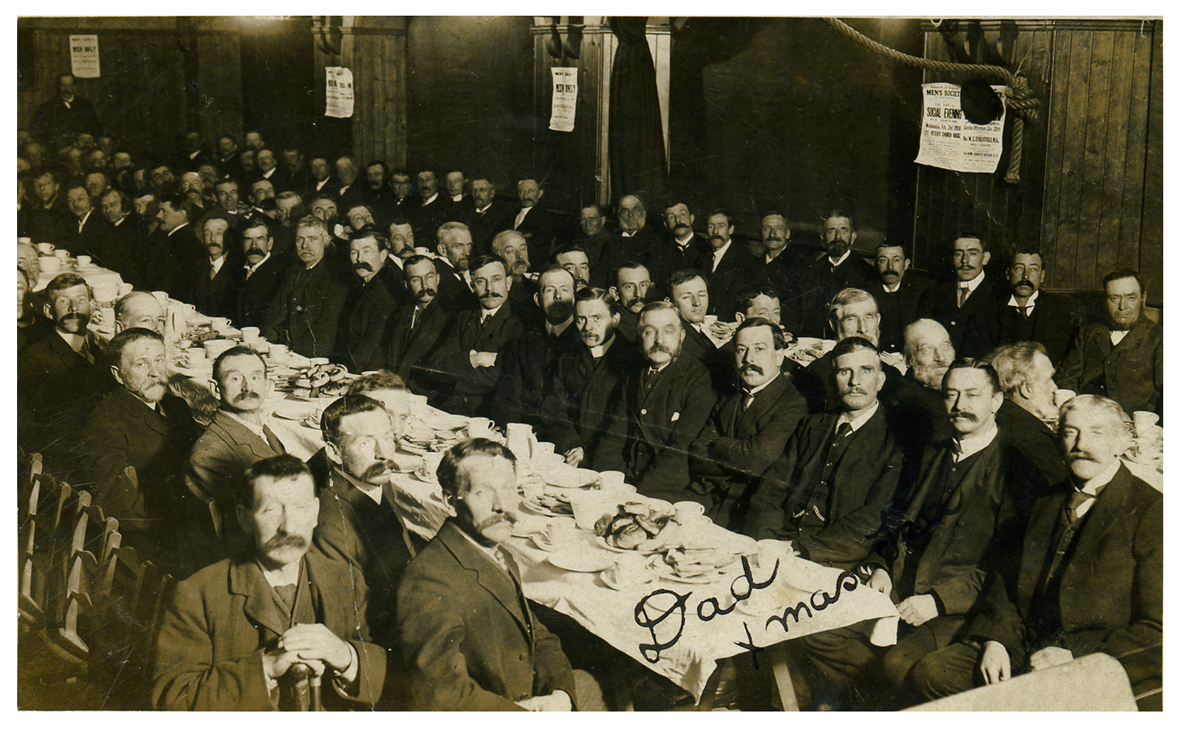 Photo at St Peter's Church Hall. "Fathers' Xmas Tea - Mr E Bowles, Mr G Bowles. A great event for these hard working men"